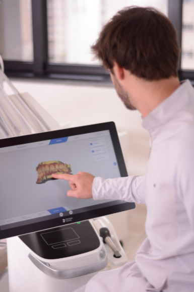 Dentista da Clínica De Bortoli utilizando scanner digital e modelo 3D da arcada dentária